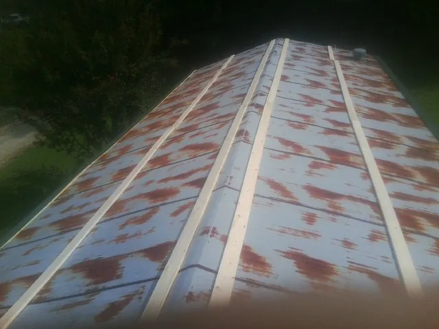 Rusted metal roof panels with new wood purlins before replacement — Storm Damage Roof Repair in Trade by Roofing Brothers