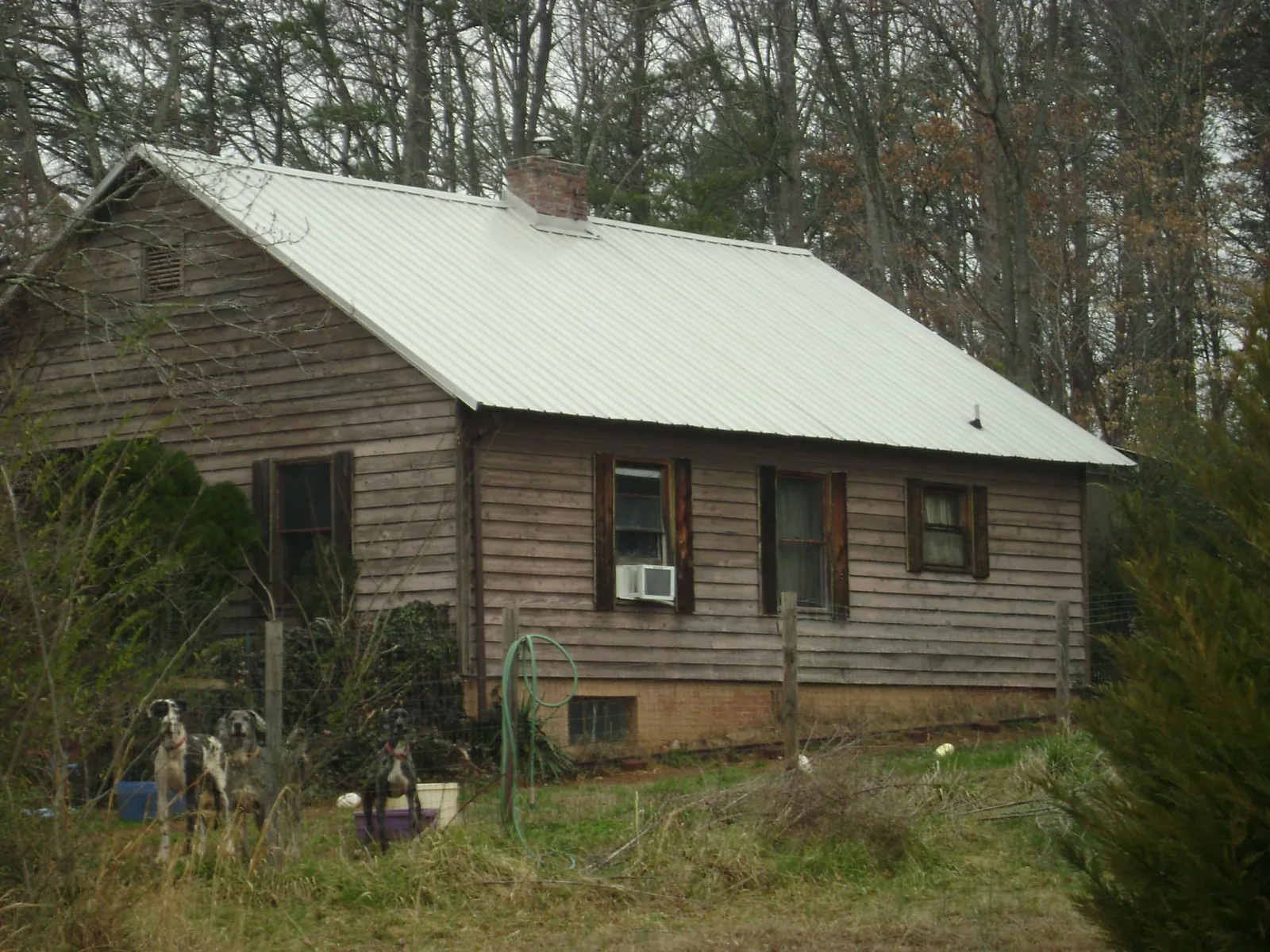 White metal roof on an old wood sided farmhouse, from a Metal Roof Installation job in Trade